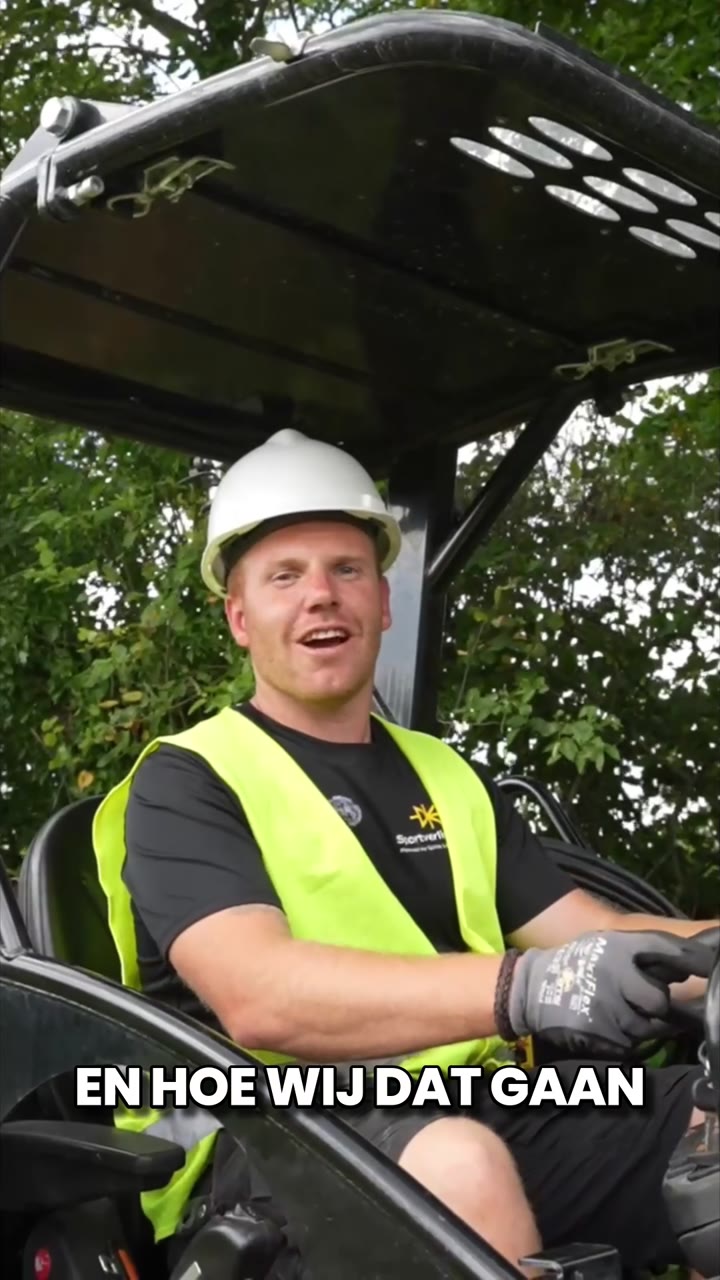 Monteur met helm en hesje bij een lichtmast op het sportpark van De Witkampers